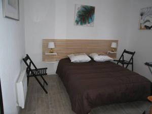 sypialnia z dużym łóżkiem i dwoma krzesłami w obiekcie Appartement T2 rénové, 4 couchages, parking, face plage, centre de Saint-Cyprien - FR-1-106-74 w mieście Saint-Cyprien
