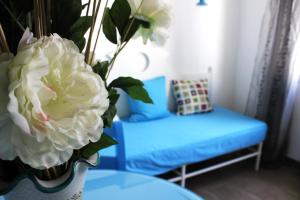 a vase with white flowers on a table with a bench at Hotel O'scià in Lampedusa