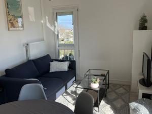 - un salon avec un canapé bleu et une fenêtre dans l'établissement Appartement Cabourg, 2 pièces, 4 personnes - FR-1-794-71, à Cabourg