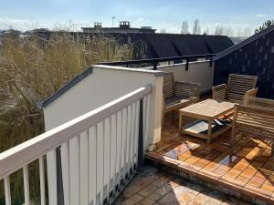 une terrasse avec deux chaises et une table en bois dans l'établissement Appartement Cabourg, 2 pièces, 4 personnes - FR-1-794-71, à Cabourg