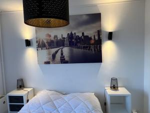 - une chambre avec un lit et une photo sur le mur dans l'établissement Appartement Cabourg, 2 pièces, 4 personnes - FR-1-794-71, à Cabourg