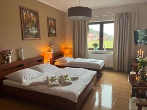 a hotel room with two beds and a window at Villa Dudziak in Słubice