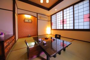 a dining room with a table and chairs and windows at Hotel Claire Higasa in Himeji