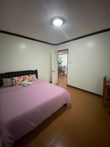 Silang的住宿－Rachel’s Bed and Breakfast，卧室配有粉红色的床。