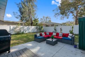 a patio with a red and blue couch and a grill at Upscale 2br House Wprivate Yard & Parking in St. Petersburg