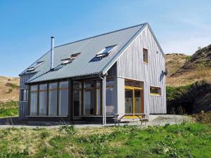 a house with a metal roof on top of a hill at Seascape in Fiskavaig