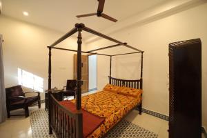 a bedroom with a canopy bed in a room at Le Pondy Home Stay in Pondicherry