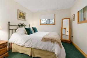 ein Schlafzimmer mit einem großen Bett und einem Spiegel in der Unterkunft Bear Essentials Hideaway in Huntsville