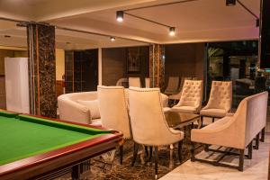 曼谷的住宿－Anandpura Riverside Hotel，配有台球桌和椅子的房间