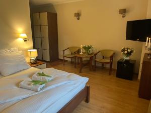 - une chambre avec un lit et une table avec des chaises dans l'établissement Villa Dudziak, à Słubice
