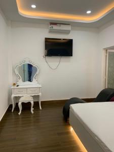 1 dormitorio con cama y tocador con espejo en Hotel MAI TUAN Nguyễn Văn Linh en Phú Khương