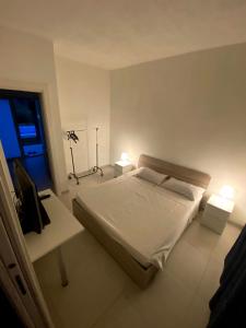 a bedroom with a bed and two tables and two lamps at Casa vacanza le tre palme in Floridia