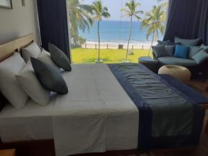 um quarto com uma cama e vista para a praia em The Lighthouse Negombo em Negombo