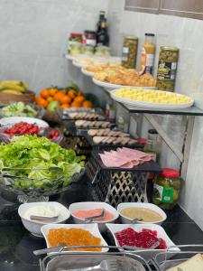 a buffet with plates of food and bowls of food at Aspaces Serviced Apartments - Vinhomes West Point in Hanoi