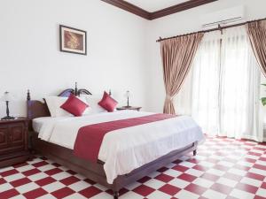 a bedroom with a bed and a checkered floor at Chateau d'Angkor La Residence in Siem Reap