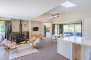 a kitchen and living room with a table and chairs at Anam Cara Gardens luxury Villa in Otaki