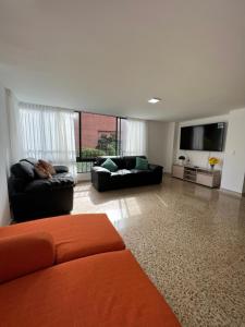 sala de estar con 2 sofás y TV de pantalla plana en 232 mt2, Mejor ubicación en Medellín al lado del tesoro, en Medellín