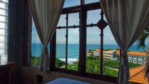 Schlafzimmer mit einem Fenster mit Meerblick in der Unterkunft Puri Uluwatu Villas in Uluwatu