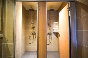 a bathroom with a walk in shower and a glass door at Good Day Hostel in Bangkok