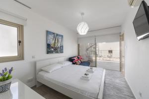 a white bedroom with a bed and a window at Protaras Sunrise Beach Villa 2 in Protaras +35 photos
