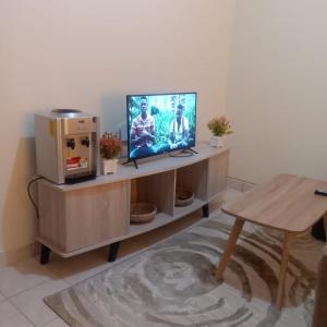 a living room with a television and a table at Kendy’s Cozy Haven in Mombasa
