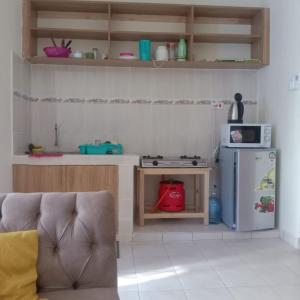 a small kitchen with a refrigerator and a microwave at Kendy’s Cozy Haven in Mombasa