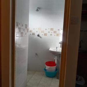 a bathroom with a sink and a toilet and a shower at Kendy’s Cozy Haven in Mombasa