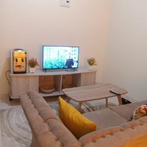 a living room with a couch and a tv at Kendy’s Cozy Haven in Mombasa