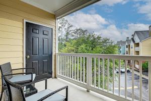 a balcony with a black door and a chair at Westside Retreat with Private Balcony Nr DWTN Jax in Jacksonville