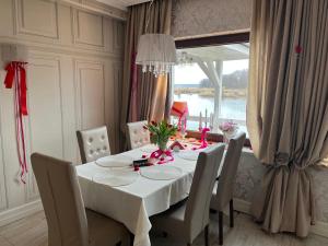 jadalnia ze stołem z krzesłami i oknem w obiekcie Villa Dudziak w Słubicach