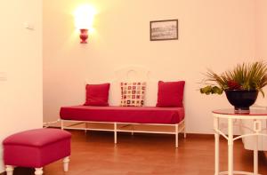 a red bench in a room with a table and a lamp at Hotel O'scià in Lampedusa