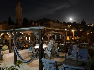 um parque infantil com cadeiras e um baloiço à noite em Sweet ‘En Kerem View em Jerusalém
