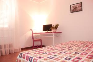 a bedroom with a bed and a desk with a computer at Hotel O'scià in Lampedusa