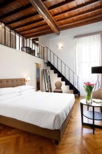 a bedroom with a large bed and a staircase at Splendor Suite Rome - Suites & Apartments in Rome