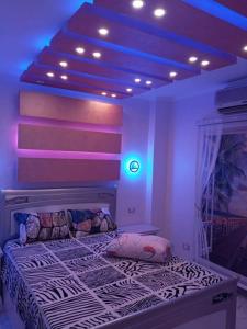 - une chambre dotée d'un lit avec des lumières violettes dans l'établissement شقة مفروشة سوبر لوكس بالمريوطية هرم, au Caire