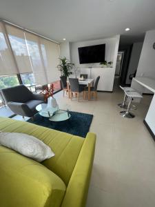 sala de estar con sofá verde y mesa en Apartamento con full entretenimiento, en Medellín