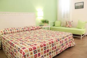 a bedroom with a bed and a chair in it at Hotel O'scià in Lampedusa