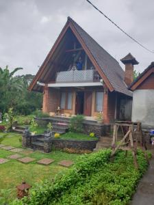 a man standing on the balcony of a house at Villa Pondok Dauh Saba in Tabanan