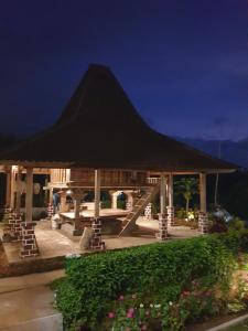a pavilion with a large black roof at night at Villa Pondok Dauh Saba in Tabanan