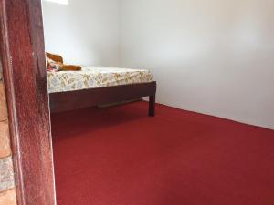 a bedroom with a bed with a red carpet at Villa Pondok Dauh Saba in Tabanan