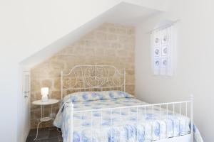 a white bedroom with a bed and a table at emozioni di casa Barone in Scicli