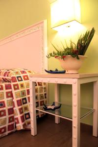a table with a potted plant on it next to a bed at Hotel O'scià in Lampedusa