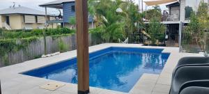 a swimming pool in the backyard of a house at Maple Villa - The Beach House by the bay in Brisbane
