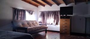 1 dormitorio con sofá, TV y tocador en Casa en Saladillo en Saladillo