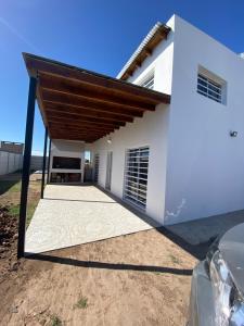 une grande maison blanche avec un toit en bois dans l'établissement Casa en Saladillo, à Saladillo