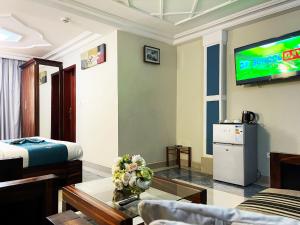 ein Wohnzimmer mit einem TV an der Wand in der Unterkunft Hotel Le Kremlin Yaoundé in Jaunde