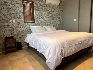 sypialnia z łóżkiem z białą kołdrą w obiekcie HERO VILLA ocean suite w mieście Ishigaki