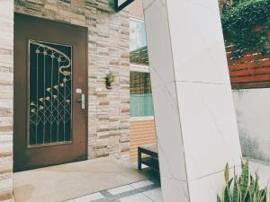 a front door of a house with a bench at Wanna Travel B&B in Taitung City