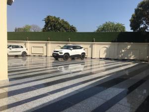 a white car parked in a parking lot at Regenta Place Jhansi by Royal Orchid Hotels Limited in Jhānsi