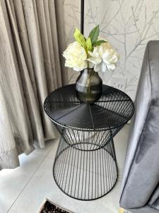 a black table with a vase with flowers on it at M Luxury Home In Irene Centurion-No Blackouts in Centurion